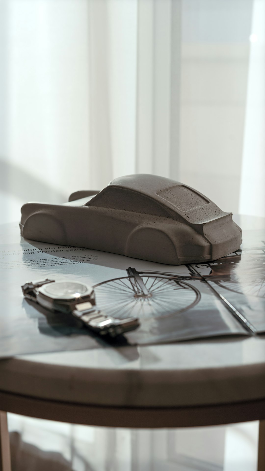 clay-car-model-and-wristwatch-on-a-table-arbliq-9tiw